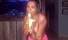 Desi dekle vadi svoje oralne sposobnosti na banani, medtem ko razkazuje svoje majhne prsi