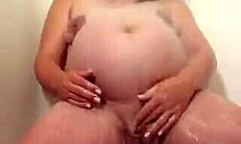 Kobieta w ciąży zmysłowo masturbuje się pod prysznicem
