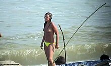 Bombshell tanpa baju menunjukkan payudaranya yang montok di pantai nudis