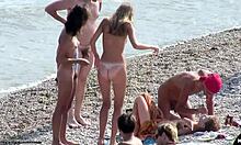 Poredne gole prijateljice se pogovarjajo in so poredne na plaži