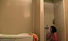Соблазнительная женщина расслабляется под душем и получает наблюдение