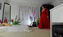Video rumah Sonias yang sensual dan dewasa menampilkan pose menggodanya dalam gaun merah panjang, mengungkapkan rok berbulu, kaki, kaki, dan pinggulnya, dengan payudara alami