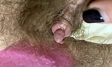 Ekstrem nærbillede af en stor klitoris fisse bliver gnidtet og sprøjtet